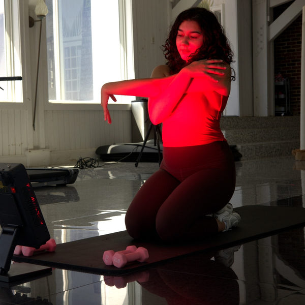 Woman stretching in front of the AWA FX500 red light panel